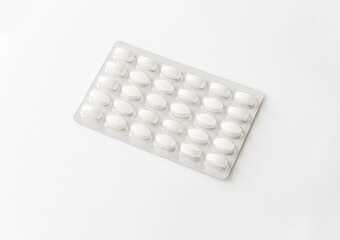 White pills tablets in package on a white background. Capsule pills in plastic pack for pharmacy and medicine.