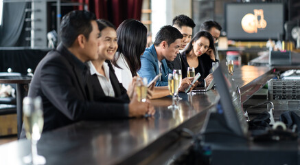 Group Of Asian Friends Enjoying Evening Drinks in bar. Celebration, Party People Christmas and Happy new year concept. Asian business people in party.
