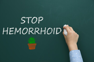 Little child writing phrase Stop Hemorrhoid on chalkboard, closeup