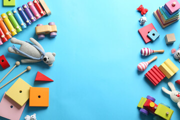 Flat lay composition with different toys on light blue background. Space for text