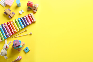 Flat lay composition with different toys on yellow background. Space for text