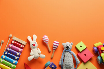 Flat lay composition with different toys on orange background. Space for text