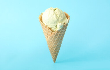 Delicious ice cream in waffle cone on light blue background