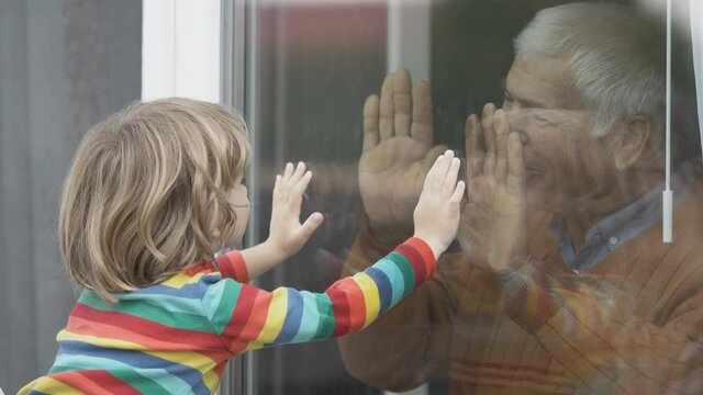 Old man indoor  play with child outdoor, touch hand through window, waving hands, kiss, sad quarantine isolation, prison, lock down, free love
