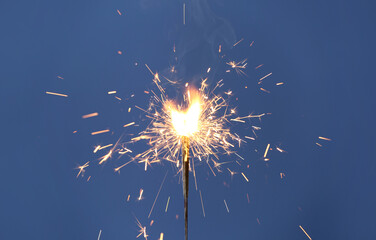 Obraz premium Beautiful sparklers burning on blue background. Party decor