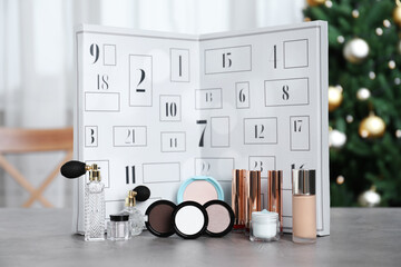 Christmas advent calendar with perfumes, skin care and decorative cosmetics on table