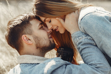 Woman in a jeans clothes. Couple in a spring field. Girl makes a photo to her boyfriend.