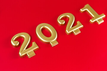 Happy New year 2021 celebration. Golden numbers 2021 as a symbol of the coming year on a red background
