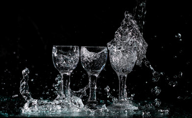 glasses with water with splashes on a black background