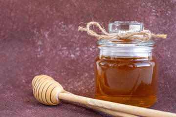 Glass can full of honey and wooden stick