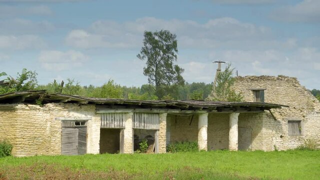 Broken brick walls of the bunk house on the lawn from the abandoned house on a sunny day