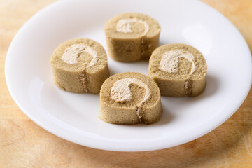 Sliced coffee roll cake on white dish