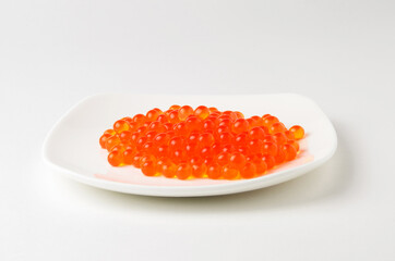 Red caviar on a white plate. Source of fat, protein, and carbohydrates.