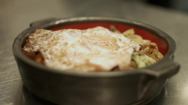 Close up of a plate with fried egg and austrian gr&ouml;stl with fresh tomatos. Racking Focus. Shot in 4K.