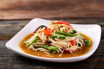 Thai food (Som Tum), Spicy green papaya salad on wooden background