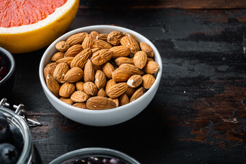 Almonds nuts with healthy food on dark wooden background, with copy space