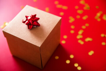 Gift wrapped on a red background and golden confetti