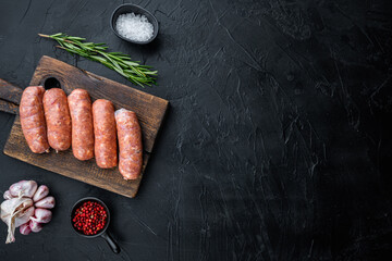 Raw pork sausages, top view with space for text, on black background