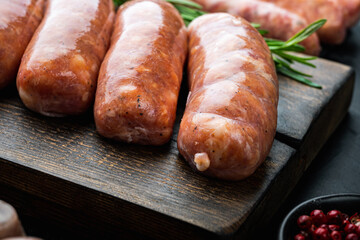 Homemade raw pork sausages, on black background