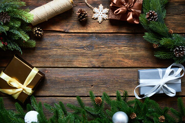 Preparing for Christmas or New Year holiday. Flat-lay of fur tree branches, evergreen wreaths, christmas wraped gift, wooden table background, top view, copy space