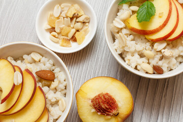 Sorghum salad with nuts and fresh peach on gray boards.