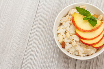 Sorghum salad with nuts and fresh peach on wooden background.