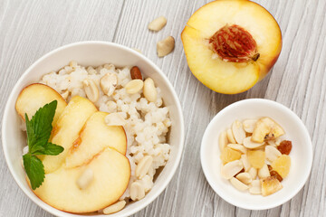 Sorghum salad with nuts and fresh peach on gray boards.