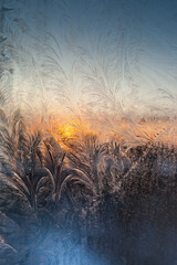 Sunset through frosty pattern on glass