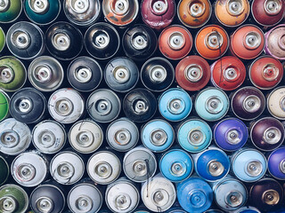 Spray paint dispenser bottles in a row stock background photography. Street art, graffiti tools. Artistic instruments.
