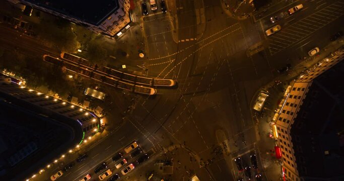 Beautiful Drone Time Lapse Hyper Lapse of Busy intersection at night in Berlin, Germany with city lights on Rosenthaler Platz, Aerial Birds Eye Top Down Overhead View, Hyperlapse