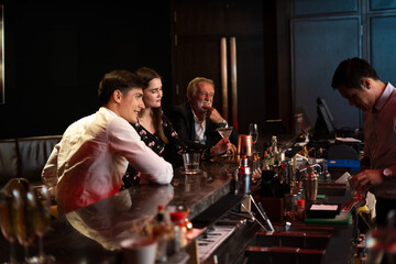 Celebration, Party People concept. Business peoples man and woman Enjoying Evening Drinks in executive bar.