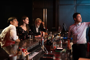 Peoples having fun watching football game on TV and drinking beverages at bar counter in nightclub