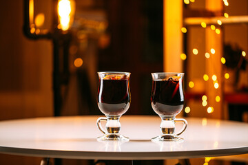 Two glass mugs of glintwine with blurry lights