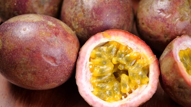 Passion Fruit rotate in slow motion on a wooden table. Exotic fruit for healthy eating