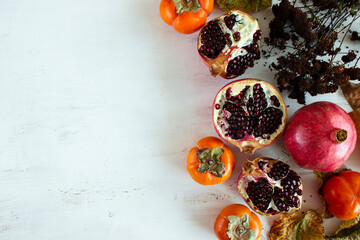 Persimmons and pomegranate fruits. Board.