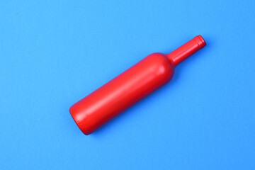 red glass bottle on blue background