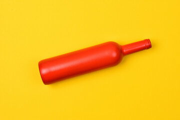 red glass bottle on yellow background