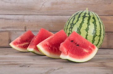 A green-skin watermelon and a few sliced watermelons