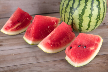 A green-skin watermelon and a few sliced watermelons