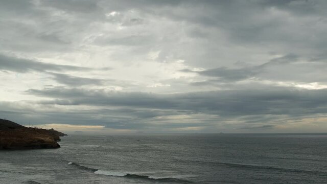 Timelapse of ocean and clouds at Sunset Cliffs in San Diego on cloudy day during golden hour