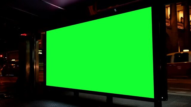 Night city street billboard stand with green screen. Green screen for text or copy.