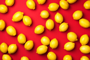 Immune system booster. Fresh lemons pattern on red background. Copy space. Top view. Flat lay. Citrus fruits. Vitamins for health. Liposomal vitamin C. Lemon for vegan, vegetarian alkaline diet