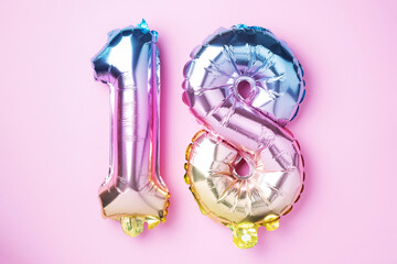 Creative layout. Rainbow foil balloon number, digit eighteen. Birthday greeting card with...