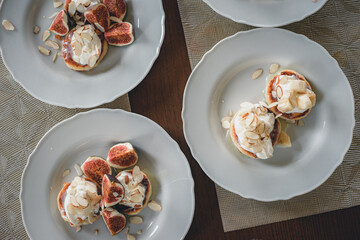 Traditional cottage cheese pancakes, cheesecake on a plate sour cream and nuts sauce, pieces of figs.