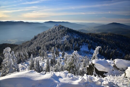 Osser Mountain in Bohemian Forest offering beautiful views of both Czech Republic and Germany, covered in snow, shown in winter.