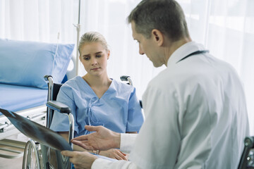 Obraz premium Doctor show and discussing with patient about x-ray film and medical treatments in examination room at hospital,Medical healthcare job, or hospital business concept.
