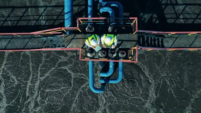 Top view of two workers at the wastewater treatment site