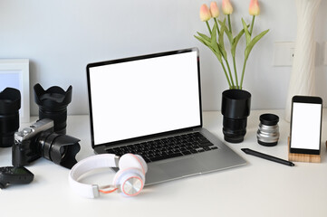 A opened laptop with white screen on  graphic designer or photographer workspace.
