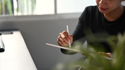 Cropped shot of graphic designer or photographer hand drawing at portable tablet computer.