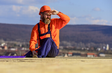 Man roofing surface. Professional master repair roof. Flat roof installation. Roofer constructing...